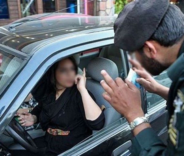 A policeman in Iran warnning a woman driver over her hijab