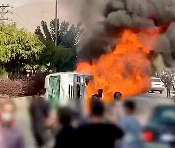 Protesters set fire to a police vehicle in Karaj, west of Tehran on November 3, 2022