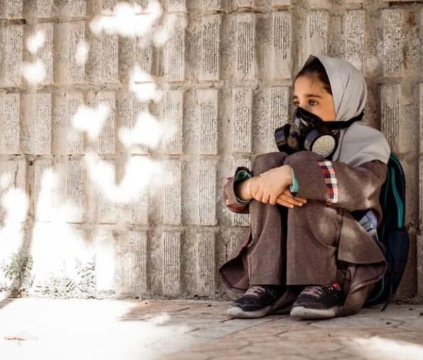 A schoolgirl breathing through a mask (file photo) 