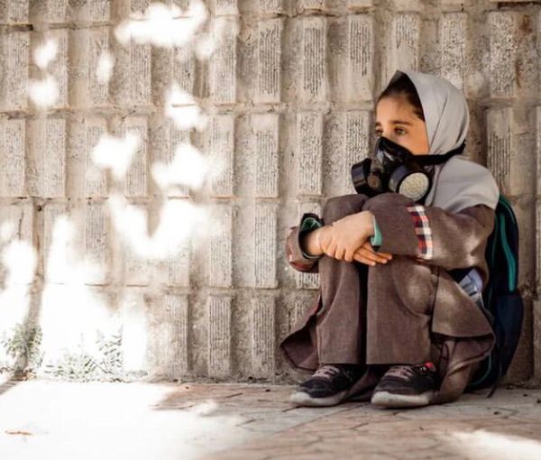 A schoolgirl breathing through a mask (file photo)