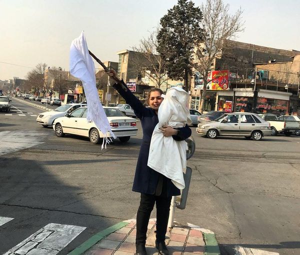A woman in Iran removes her veil in defiance of police