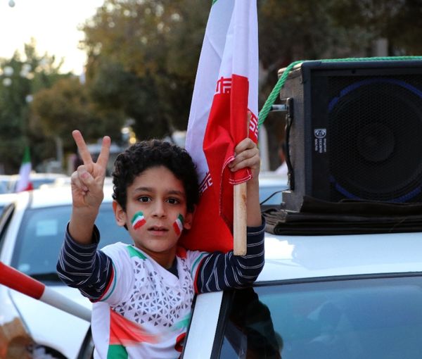 A boy celebrating Team Melli’s victory against Wales in a government-sponsored rally in the city of Kerman, central Iran (November 2022)