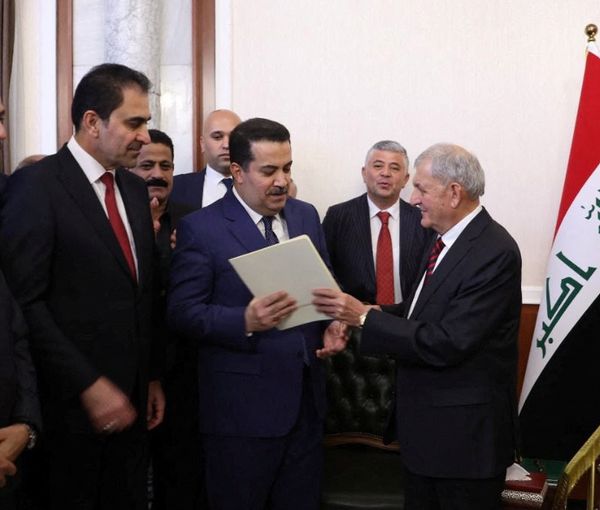 Iraq's new president Abdul Latif Rashid (R) appointing Shia al-Sudani premier on Oct. 13, 2022