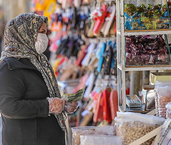 A woman looking at prices in Tehran's Bazaar, 2021