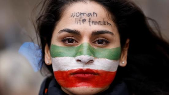 An Iranian woman with "Woman, Life, Freedom" motto written on her forehead in a rally in Brussels in February