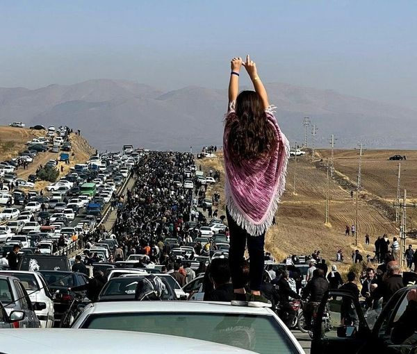 A large crowd marching to a cemetery in the hometown of Mahsa Amini to pay tribute to her, on October 26, 2022