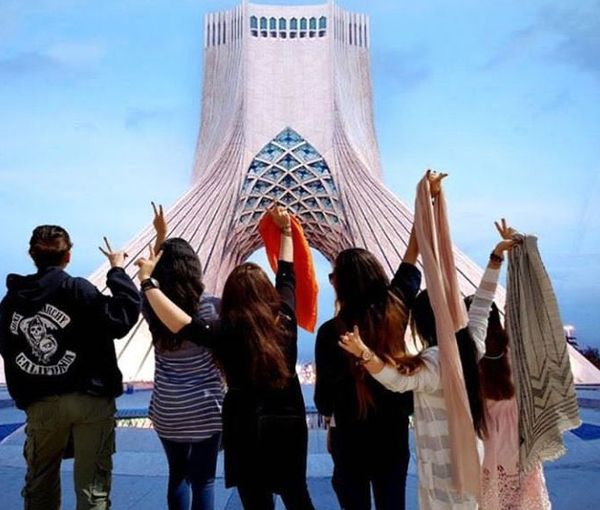 Several Iranian women remove their headscarves in front of Tehran’s iconic Azadi tower, formerly known as the Shahyad Tower.