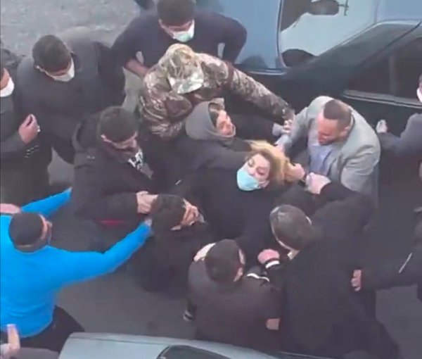Plainclothes agents assaulting a mother outside an Iranian school where girls were poisoned by a mysterious gas. March 1, 2023