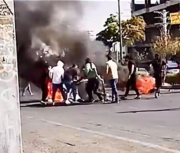Protesters setting fire to trash bins in a street in October, 2022