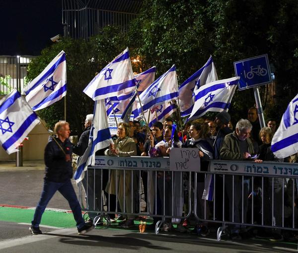 People demonstrate outside the residence of Israeli President Isaac Herzog as he hosts talks over judicial reforms, in Jerusalem, March 28, 2023.