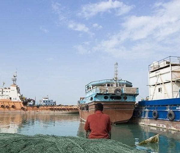 A typical small ship at anchor in an Iranian port. Undated