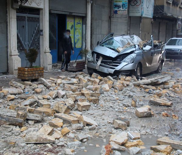 A man stands near a damaged vehicle, following an earthquake, in rebel-held Azaz, Syria February 6, 2023