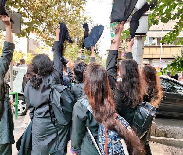 Schoolgirls removing their headscarves during protests in October 2022