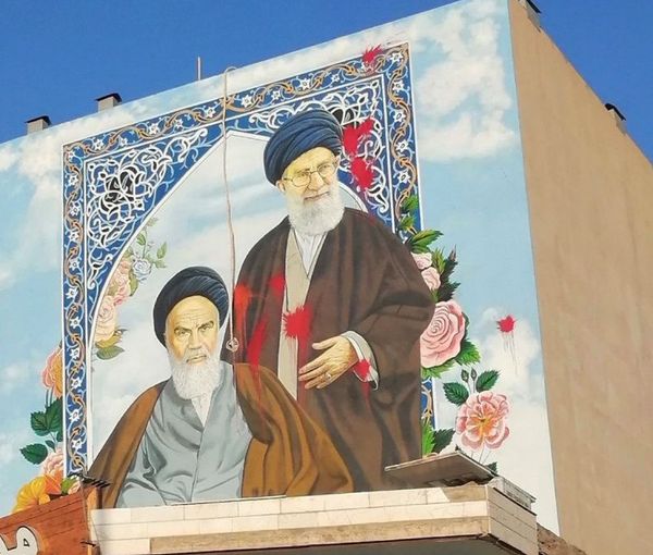 Red paint thrown by protesters at a large street mural of Ayatollah Rouhollah Khomeni and Ali Khamenei. October, 2022