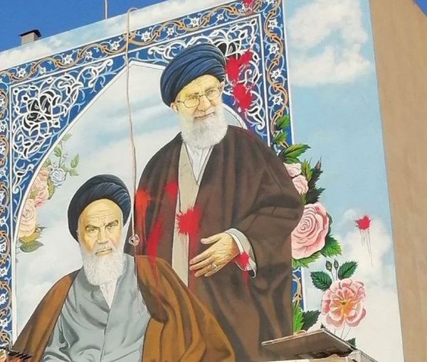 Red paint splashed on a large mural of Khomeni and Khamenei to symbolize regime bloodshed. October 31, 2022