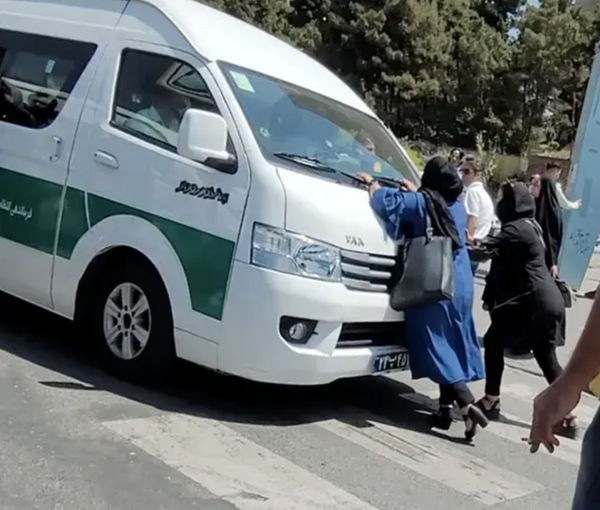 A mother trying to stop a police van that arrested her daughter for hijab. July 19, 2022