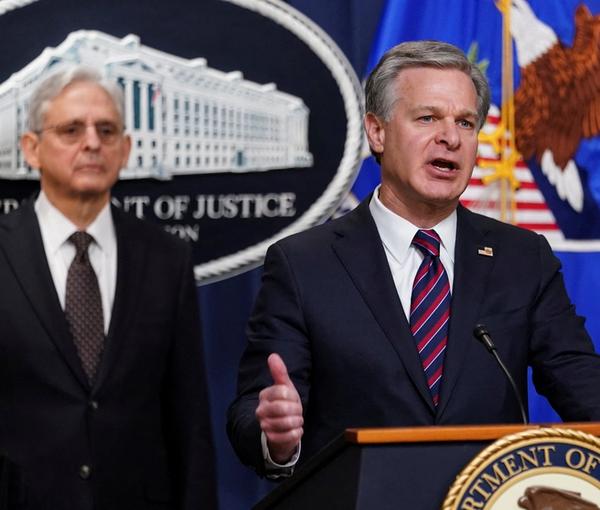 FBI Director Christopher Wray is flanked by U.S. Attorney General Merrick Garland, as he discusses charges against three members of an Eastern European criminal organization with ties to Iran's government with conspiring to assassinate a journalist and activist who is a U.S. citizen, during a news conference at the Justice Department in Washington, U.S., January 27, 2023