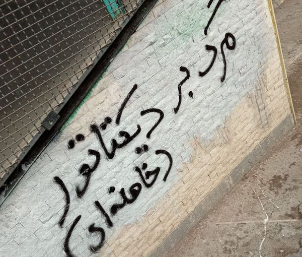 A slogan written on a wall says, "Death to the dictator, Khamenei"