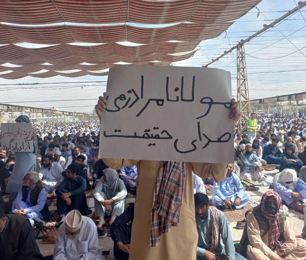 An Iranian man holding a placard in support of the Sunni leader of Zahedan, Mowlavi Abdolhamid, during Friday prayers on March 10, 2023  