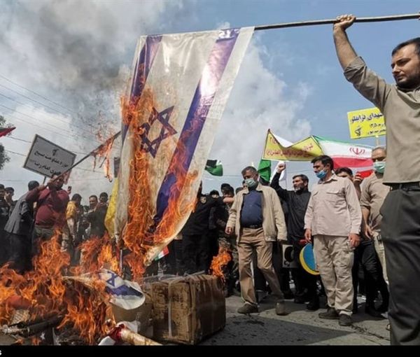 Iranian regime supporters burning an Israeli flag on Quds Day in 2022