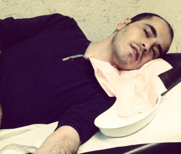 An older photo of Hossein Ronaghi receiving medical help