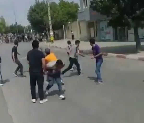 People throw stones at security forces who attacked them to disperse their protests in the Kurdistan province on September 19, 2022 