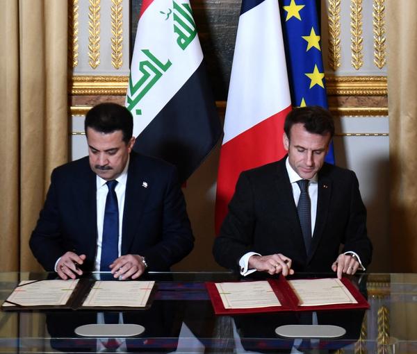 French President Emmanuel Macron and Iraq's Prime Minister Mohammed al-Sudani sign documents at the Elysee Presidential Palace, in Paris, France, January 26, 2023.