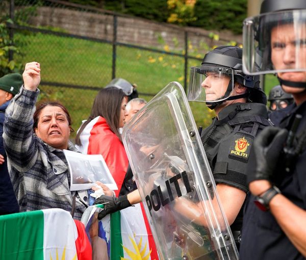 Police officers stand guard as people attend a demonstration at Iran's embassy in Oslo, Norway, September 29, 2022.