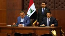 Iraqi Prime Minister Mohammed Shia al-Sudani looks on as Iraq's National Security Adviser Qasim al-Araji and Iran's Supreme National Security Council secretary Ali Shamkhani sign a security agreement, in Baghdad, March 19, 2023