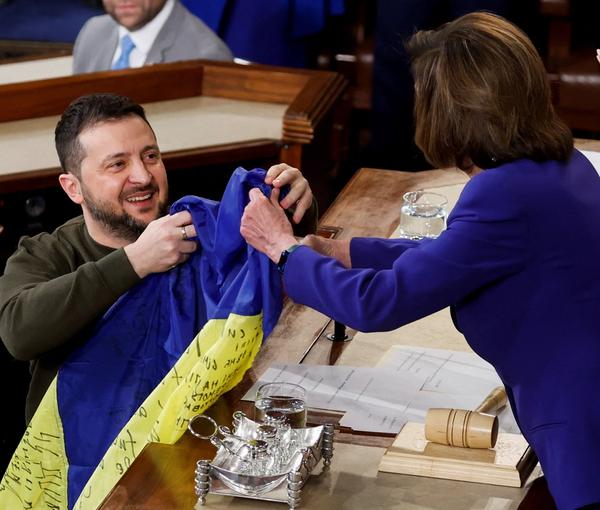 President Volodymyr Zelenskiy presents a Ukrainian flag given to him by defenders of Bakhmut to US House Speaker Nancy Pelosi during a joint meeting of US Congress, December 21, 2022