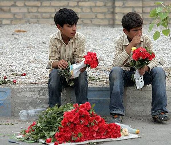 Children selling flowers on a street in Tehran (file photo) 