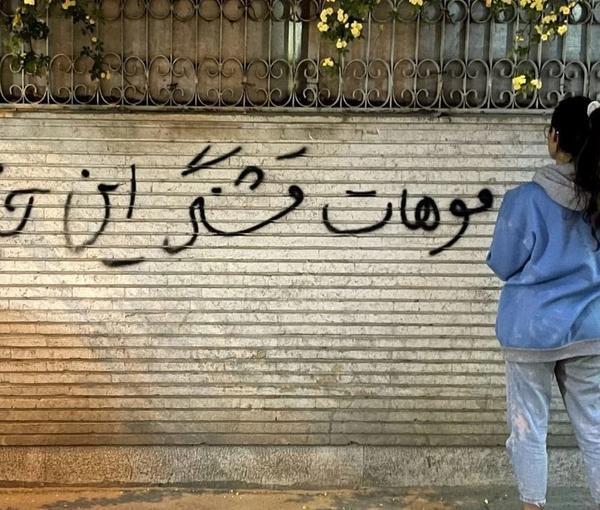 An Iranian woman unveiling in public to protests against the mandatory hijab (file photo)