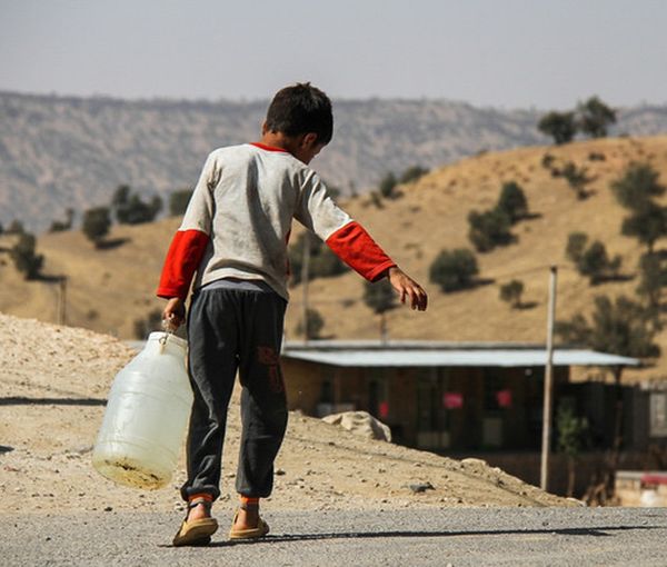 An Iranian boy carrying a water gallon (file photo)