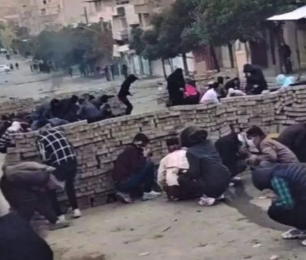 Kurdish civilian protesters hiding behind a makeshift barricade on Nov, 19, 2022