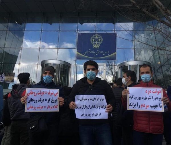 Small investors protesting outside Tehran stock exchange in 2021, holding signs calling the government "a thief".