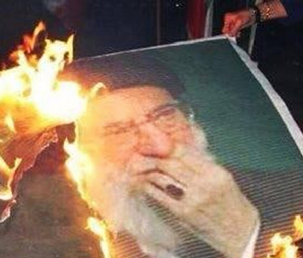 A burning banner of Iran’s ruler Ali Khamenei (file photo) 