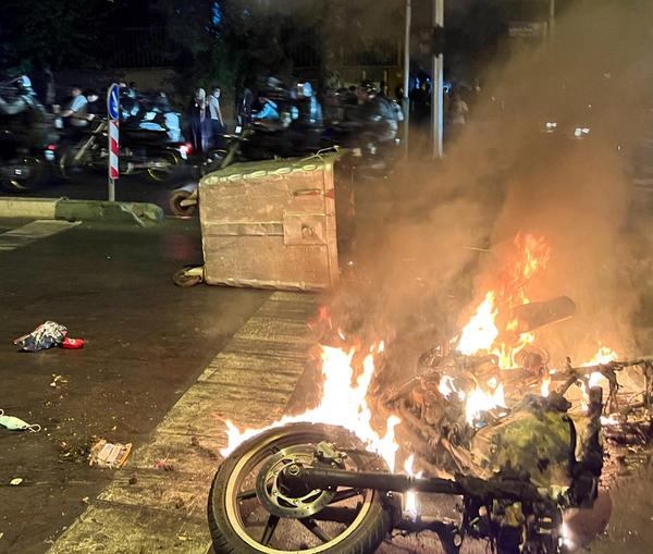 Protesters set fire to a motorcycle of security forces in Tehran on September 19, 2022