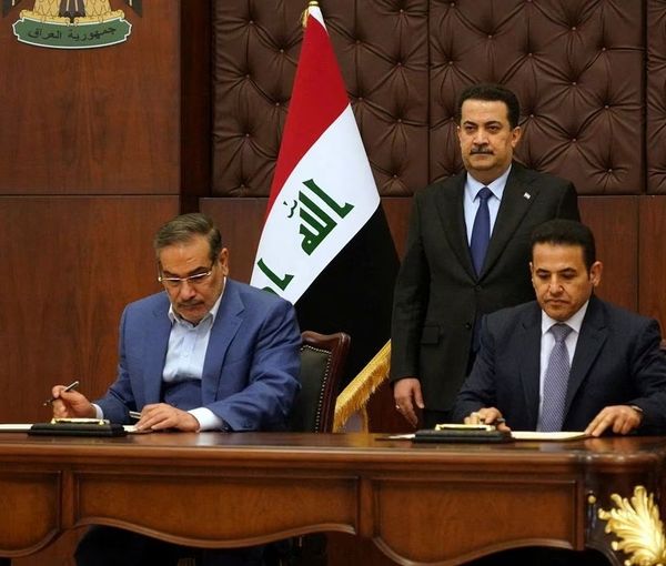 Iraqi Prime Minister Mohammed Shia al-Sudani looks on as Iraq's National Security Adviser Qasim al-Araji and Iran's Supreme National Security Council secretary Ali Shamkhani sign the security agreement that includes coordination in protecting the common borders between the two countries, in Baghdad, Iraq, March 19, 2023.