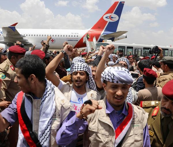 Freed prisoners walk after arriving at Sanaa Airport on an International Committee of the Red Cross (ICRC)-chartered plane, amid a prisoner swap between two sides in the Yemen conflict, in Sanaa, Yemen April 14, 2023.