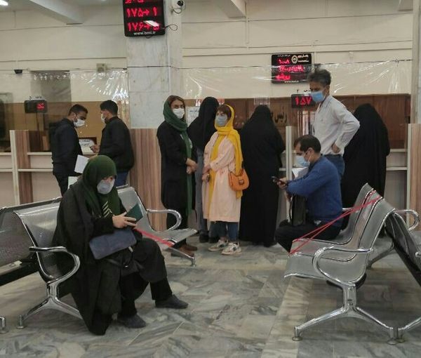 People stand in a line inside a bank (file photo)