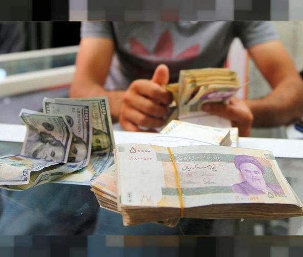 A money changer is counting a pile of Iranian banknotes in Tehran