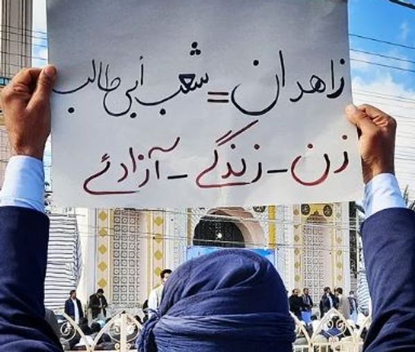 A protester in Zahedan holding a placard that reads the main motto of the protests: women, life, liberty 