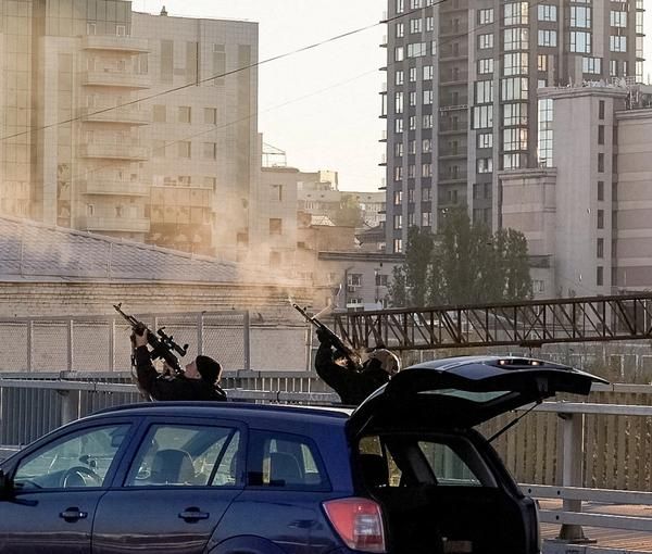 Police officers shoot at a drone during a Russian drone strike, which local authorities consider to be Iranian-made Shahed-136 unmanned aerial vehicles (UAVs), amid Russia's attack on Ukraine, in Kyiv, Ukraine October 17, 2022.