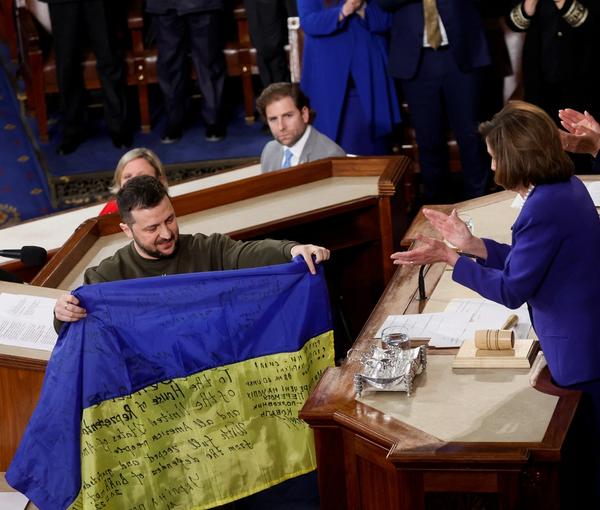 Volodymyr Zelanskyy presenting a Ukrainian flag to Nancy Pelosi at US Congress on December 21, 2022